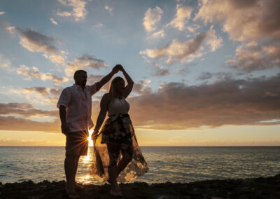 Silhouette of dancing honeymoon couple by ocean